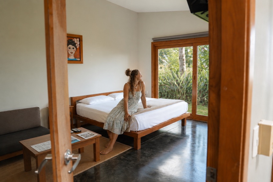 Guest sitting on the bed in the Oceanview Studio