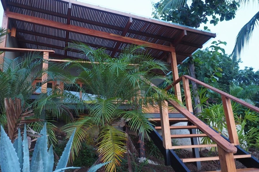 Stairs and covered deck of the Sunrise Studio among tropical plants